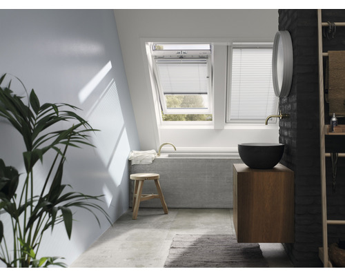 Badkamer met dakramen, wastafel, spiegel en decoratie