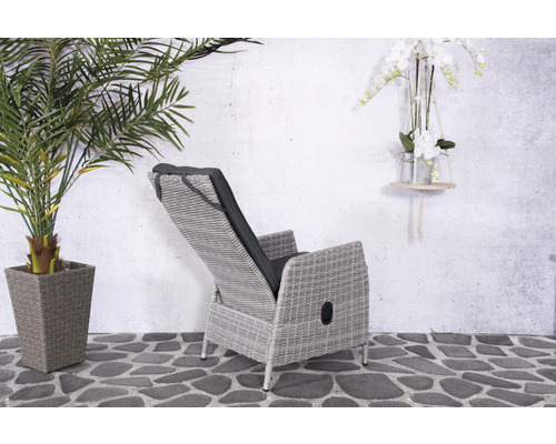 Tuinligstoel van rotan met kussens op een terras