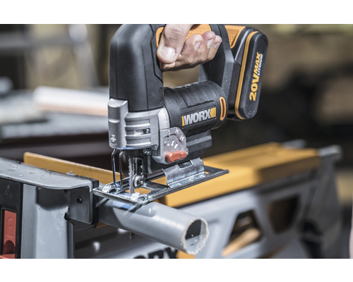 Accu decoupeerzaag snijdt een pijp op een werkbank