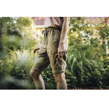 Vrouw in de tuin met een tuinschaar.