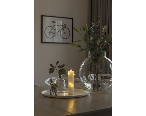Decoratieve tafelopstelling met kaars, bloemen en fietsafbeelding