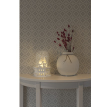 Decoratie met verlicht huisje, vaas en droogbloemen op een tafel