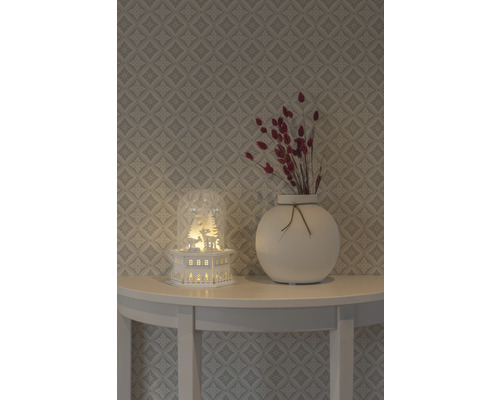 Decoratie met verlicht huisje, vaas en droogbloemen op een tafel