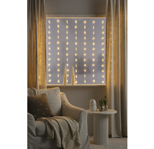 Decoratieve woonkamer met sterrenlichtjes voor het raam, fauteuil en bijzettafel