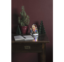 Decoratieve opstelling met bureau, notitieboek, pen, kerstbomen en verlichte kerstscène