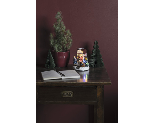 Decoratieve opstelling met bureau, notitieboek, pen, kerstbomen en verlichte kerstscène