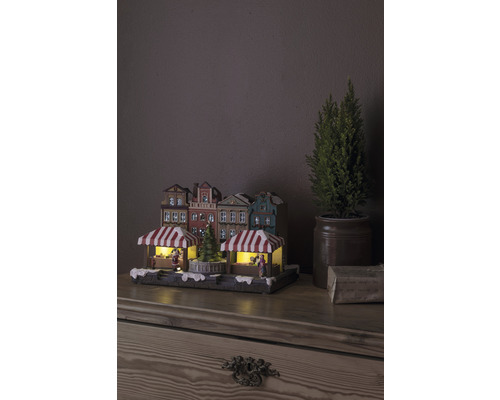 Kerstmarktdorp met verlichting en decoratieve huizen op een tafel