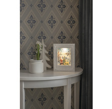 Decoratieve kerstscène met verlicht frame op een tafel