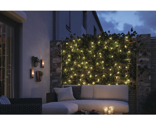 Sfeervolle tuinscène met lichtsnoer, buitenverlichting en zithoek voor de Hornbach webshop.