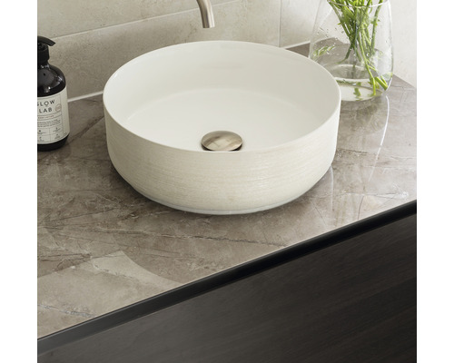 Opzetwastafel van keramiek op een wastafelblad in een badkamer