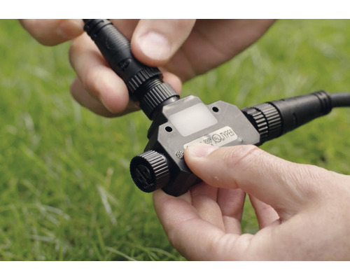 Persoon sluit T-stuk aan voor laagspannings tuinverlichting