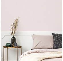 Decoratieve slaapkamer met wandpaneel, nachtkastje, kussens en decoratieartikelen