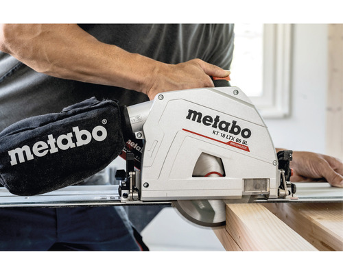 Metabo Logo. Man bedient een Metabo accu-cirkelzaag KT 18 LTX 66 BL bij het zagen van een stuk hout.