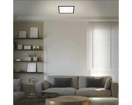 Woonkamer met bank, planken en vierkante plafondlamp