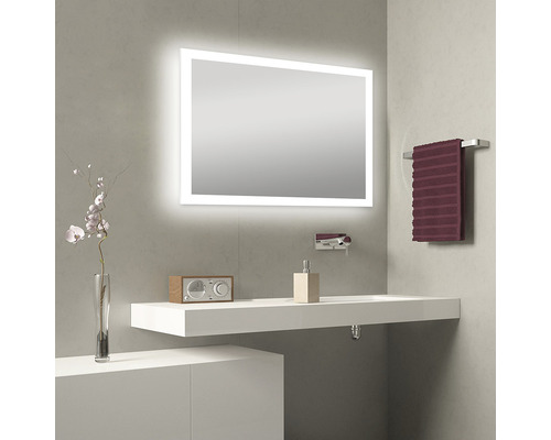 Moderne badkamer met verlichte spiegel, wastafel, kraan en handdoekhouder.