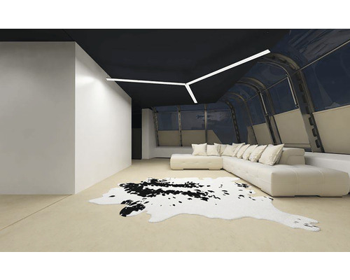 Moderne woonkamer met zwart plafond, hoekbank, koeienhuidtapijt en lineaire plafondlamp