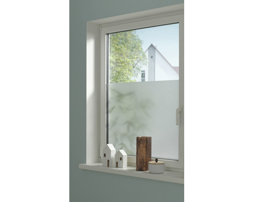 Raam met privacyfolie, versierd met huisjes en vazen