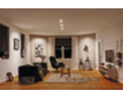 Woonkamer met bank, fauteuil, vloerkleed en decoratieve artikelen