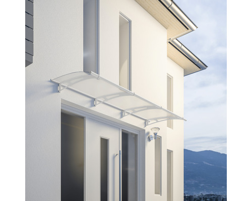 Deur afdak van transparant materiaal met een wit frame gemonteerd aan een gevel.