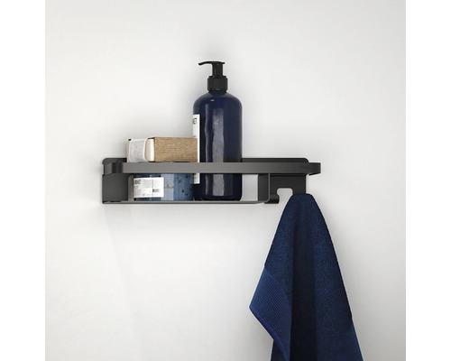 Zwarte wandplank met handdoek en badartikelen