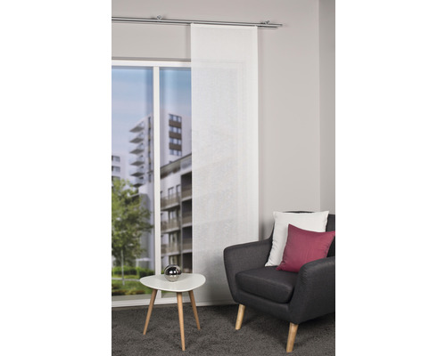 Woonkamer met raamdecoratie, fauteuil en bijzettafel voor een stijlvolle ambiance