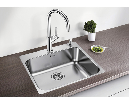 Roestvrijstalen spoelbak met kraan en zeepdispenser op een werkblad