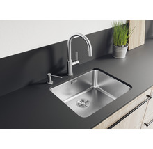 Roestvrijstalen spoelbak met kraan en zeepdispenser op een aanrecht