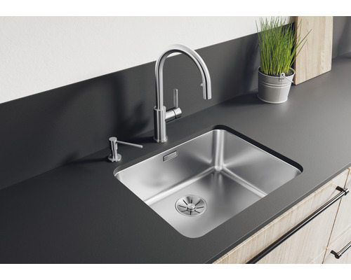 Roestvrijstalen spoelbak met kraan en zeepdispenser op een aanrecht