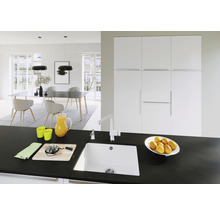 Lichte eetkamer met eettafel, stoelen, hanglampen en een spoelbak op een werkblad