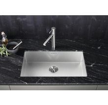 Roestvrijstalen spoelbak met kraan op een donker aanrechtblad