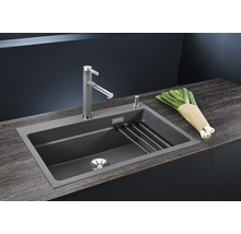 Spoelbak met kraan, afdruiprek en prei op een aanrecht