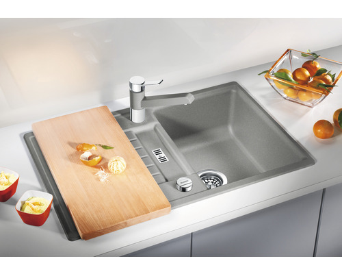 Spoelbak met snijplank en kraan op een aanrecht.