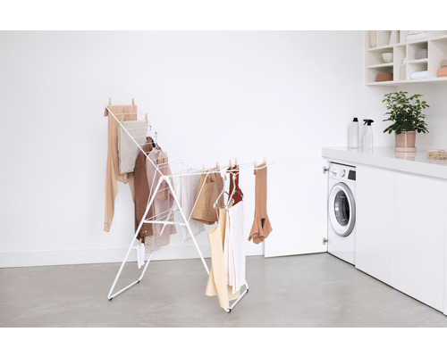 Wasrek met wasgoed in een heldere ruimte met wasmachine