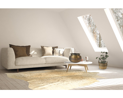 Woonkamer met bank, kussens, tafel, decoratie en tapijt in een heldere ruimte