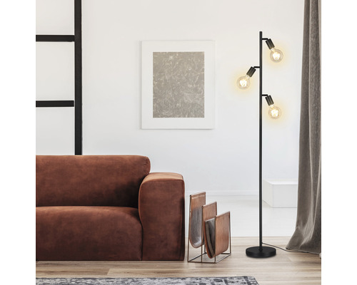 Woonkamer met vloerlamp, bank en tijdschriftenrek