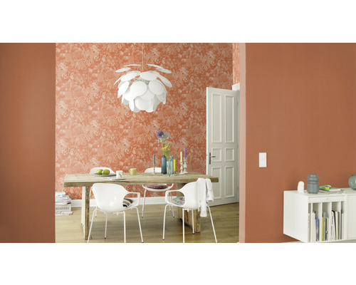 Woonkamer met eettafel, stoelen, hanglamp en patroonbehang