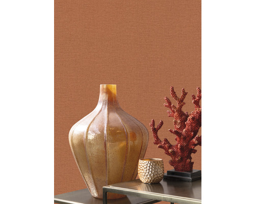 Decoratieve scène met vaas, koraal en theelichthouder op een tafel voor een muur