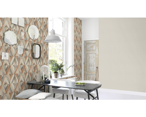 Eetkamer met geometrisch behang, eettafel en spiegels aan de muur.