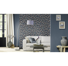 Woonkamer met patroonbehang, bank, staande lamp en decoratie