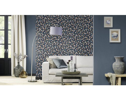 Woonkamer met patroonbehang, bank, staande lamp en decoratie