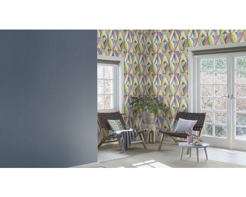 Woonkamer met patroonbehang, twee stoelen en ramen naar de tuin