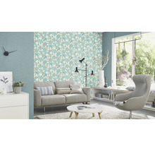Lichte woonkamer met bank, fauteuil, tafel en behang met motief