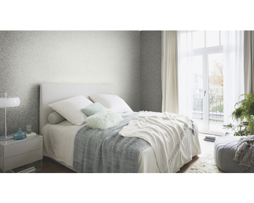 Slaapkamer met bed, nachtkastje en patroonbehang