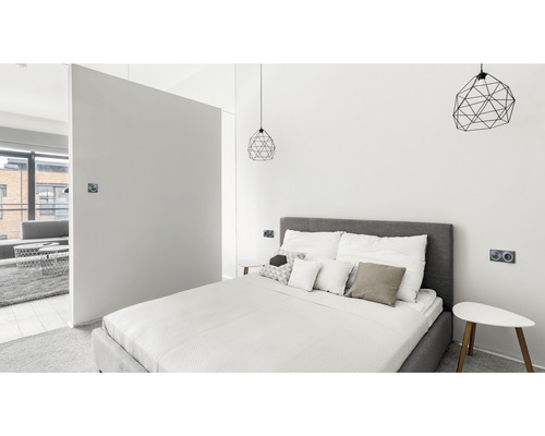 Lichte slaapkamer met bed, nachtkastjes en geometrische lampen
