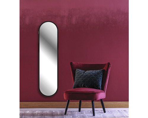 Inrichtingsvoorbeeld: Ovale spiegel, fauteuil en kussen voor een muur