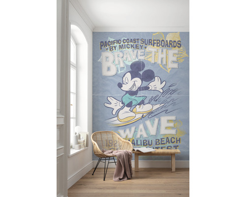Kamer met een fotobehang met Mickey Mouse die op een golf surft, met de tekst Pacific Coast Surfboards.