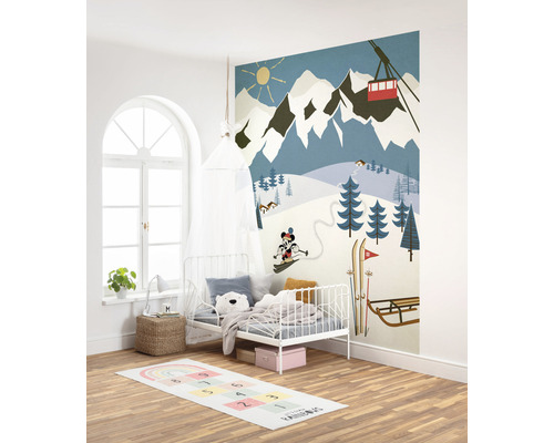 Kinderkamer met muurschildering van een besneeuwd berglandschap, bed, vloerkleed en decoratie
