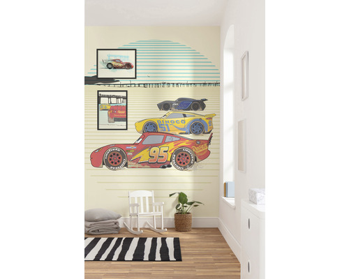 Kinderkamer met behang geïnspireerd op de film Cars, met een schommelstoel en een vloerkleed