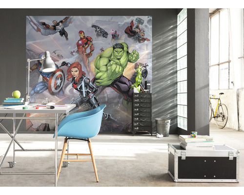 Een kamer met fotobehang met stripfiguren, een bureau, een stoel en een rolcontainer.