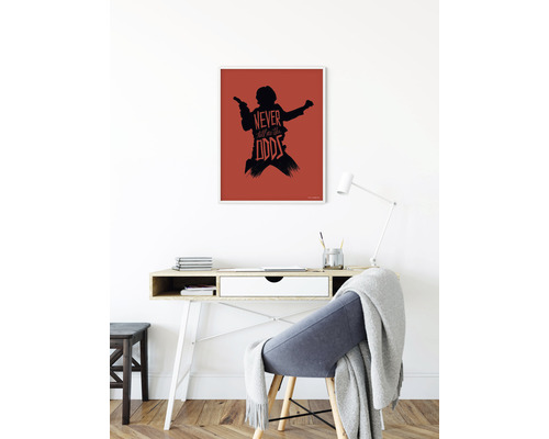 "Decoratieve ingelijste poster met silhouet van een figuur en de tekst ""Never tell me the odds"" boven een bureau"